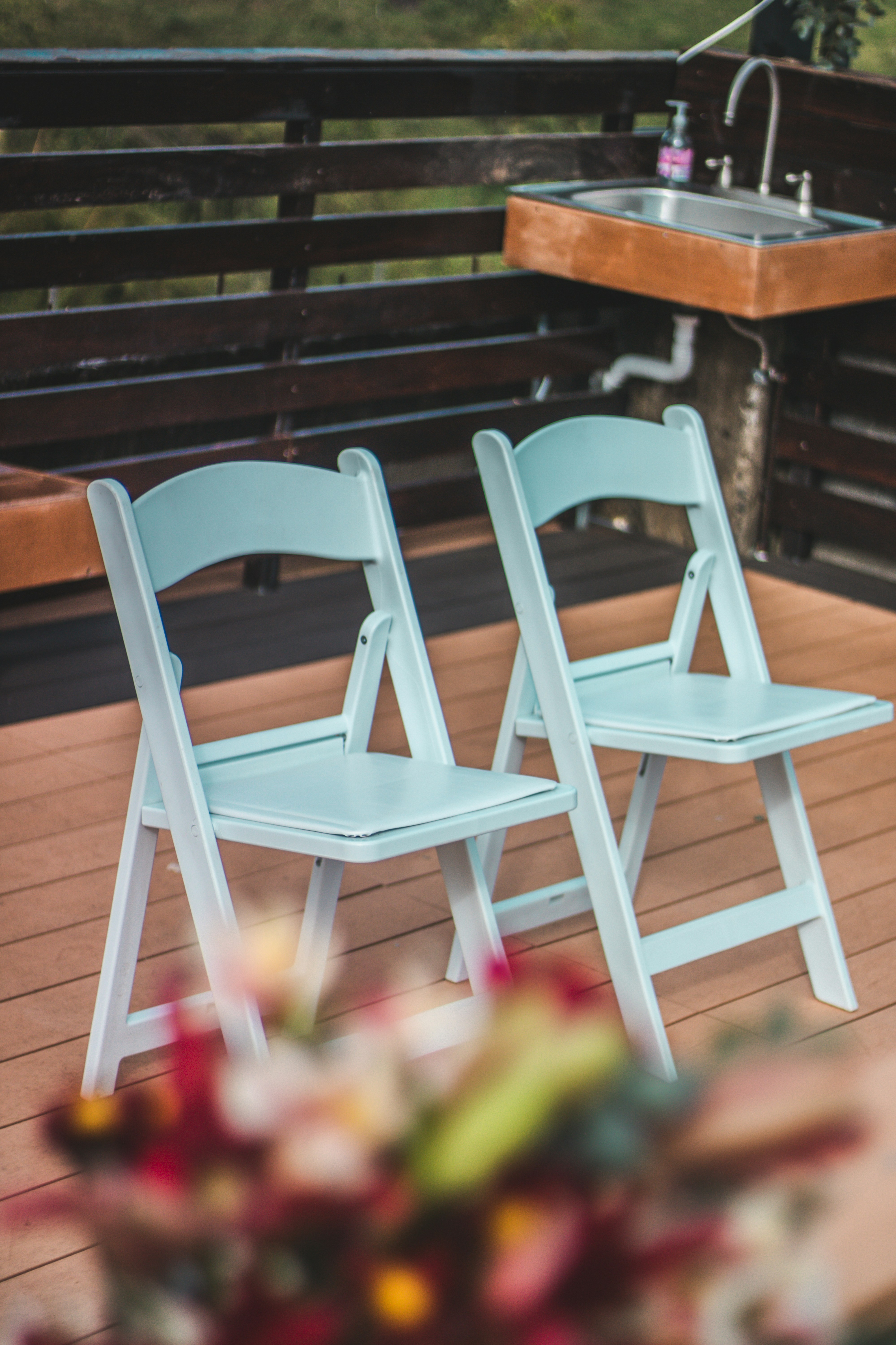 White folding chairs set up near an outdoor patio bar for an event